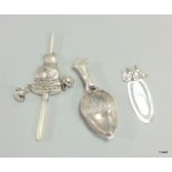 A silver babies rattle, a silver caddy spoon with acorn detail and a bookmark