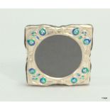 A silver and enamel set easel back picture frame