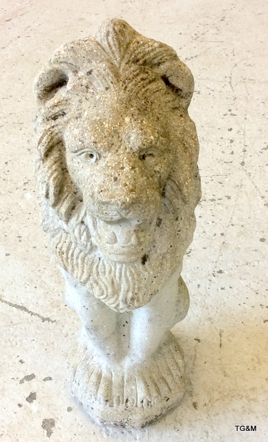 A concrete garden ornament in the shape of a lion