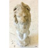 A concrete garden ornament in the shape of a lion