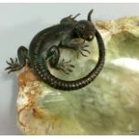 A cold painted bronze lizard on an onyx ashtray