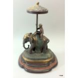 A large bronze elephant carrying a monkey with a parasol