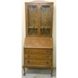 A walnut 2 part glazed bookcase bureau on cabriole legs and claw feet with 3 drawers
