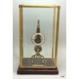A brass skeleton clock with fusee movement in a glass case