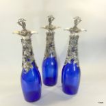 A suite of 3 Bristol Blue decanters with silver plated grape and vine decoration