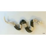 A silver marcasite and onyx snake brooch