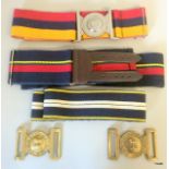 Two brass British military General Service belt buckles and three stable belts