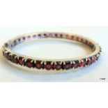 A silver and garnet set bangle