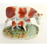 A Staffordshire flat back cow and calf figure