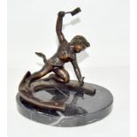 A bronze figure of a putto hammering a nail into a horseshoe, set on a marble base. 16cm