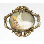 Silk miniature picture of a lady reclining on a chaise long set in a C19 gilt metal brooch