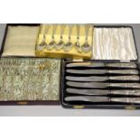 Silver handled butter knives with a boxed set of spoons and a set of cake forks