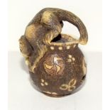 Finely carved ivory Netsuke of a cat on a bowl/jug with signature to the base