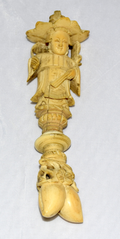 Ivory carved figure of a Chinese man standing on pine nuts