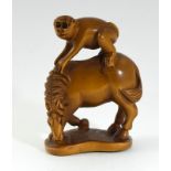 Carved Japanese netsuke depicting a monkey on a horses back signed to the base