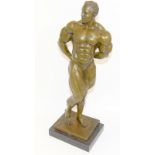 A bronze figure of a body builder set on a marble base. 50cm tall