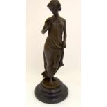 A bronze figure of a lady holding a rose, set on a marble base