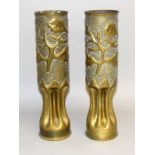 A matching pair of WW1 trench art fluted shell case vases decorated with plants 32cms by 8.5cms