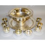 A silver plated punch bowl. Tray and 8 cups