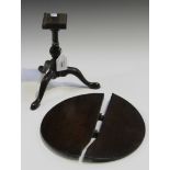 A George III mahogany diminutive tip-top table, the circular top on a turned stem and tripod legs,