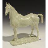 An early 20th Century white painted cast plaster figure of a standing horse, the naturalistic base