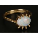 An 18ct gold ring, mounted with an oval opal in cross-over design, Birmingham 1968, ring size approx