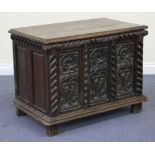 A 19th Century oak coffer with a carved triple panel front, the hinged top above a carved frieze, on