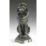 An early 20th Century green patinated cast bronze figure of a stylized seated lion, raised on a