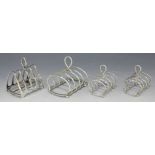 A late Victorian silver four division toast rack and two matching smaller toast racks, each with