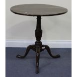 A George III mahogany circular tip-top wine table with a turned stem, on tripod cabriole legs,