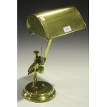 An early 20th Century brass adjustable desk lamp on a circular base.