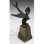 An early 20th Century patinated cast bronze model of a flying fish, raised on an alabaster pedestal,