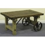 A teak and cast iron mounted coffee table, formed from three planks raised on block supports and a