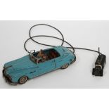 An Arnold tinplate remote control powered car, finished in light blue, with driver and passenger,