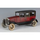 A Tipp & Co tinplate clockwork limousine with chauffeur, finished in red and black, length approx
