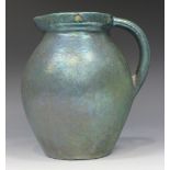 A stoneware jug, early 20th Century, the ovoid body and loop handle covered in a green iridescent