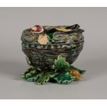 A Minton majolica box and cover, circa 1867, modelled as a goldfinch in a nest, on a base of oak