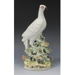 A Staffordshire pottery model of a gilt speckled bird perched on a rocky outcrop, late 19th Century,