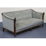 An Edwardian mahogany three-seat settee, upholstered in green floral velour, raised on turned