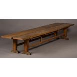 A pair of early 20th Century oak long rectangular benches designed by Edward Barnsley, the plank