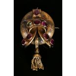 A Victorian gold and garnet set brooch of circular form, mounted with seven oval cut garnets, the