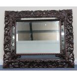 A late 19th/early 20th Century Continental carved oak sectional wall mirror, the rectangular