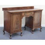 A 19th Century mahogany kneehole sideboard, fitted with a drawer flanked by cupboards, raised on