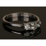 A white gold and diamond three stone ring, mounted with a row of cushion shaped diamonds with the