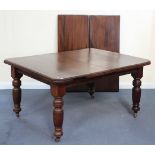 An Edwardian walnut extending dining table, the canted rectangular top with two extra leaves, raised