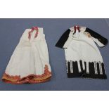 A group of five traditional Balkan dresses, all with polychrome embroidered decoration.