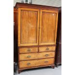 A George IV mahogany linen press, the moulded pediment above a pair of ebony line inlaid doors,