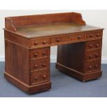 A late Victorian oak twin pedestal desk with a three-quarter gallery back, the moulded top inset