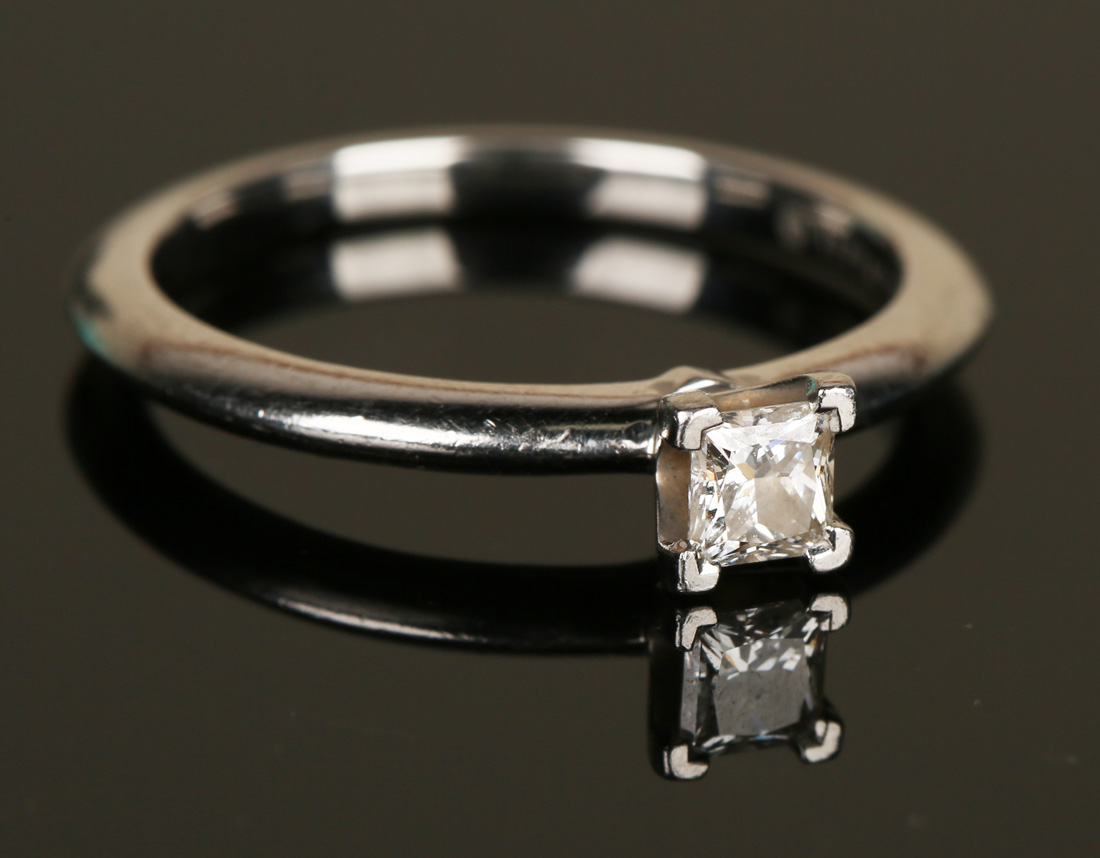 A Tiffany & Co platinum and diamond single stone ring, claw set with a princess cut diamond,