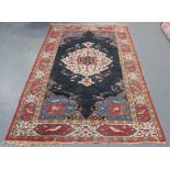 An Indian rug, early/mid-20th Century, the midnight blue field with a foliate medallion, within an